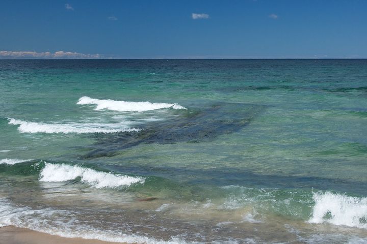 Wooden shipwreck visible beneath clear Lake Superior water off Hurricane Beach in Pictured Rocks